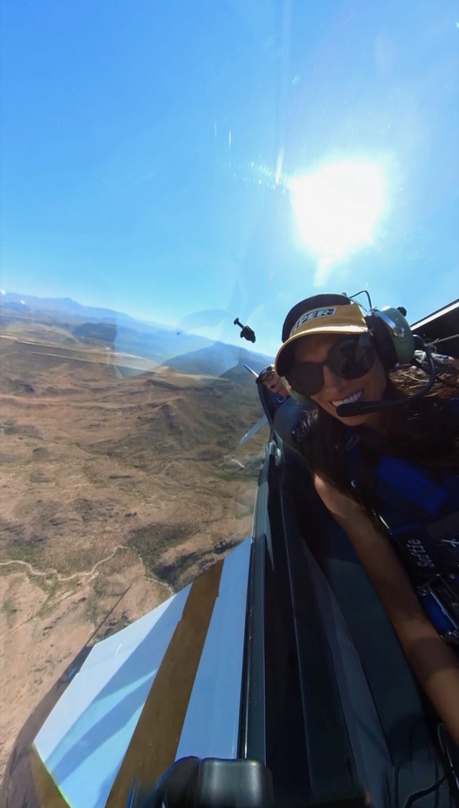 Smiling passenger enjoying a scenic flight over Arizona with a level horizon